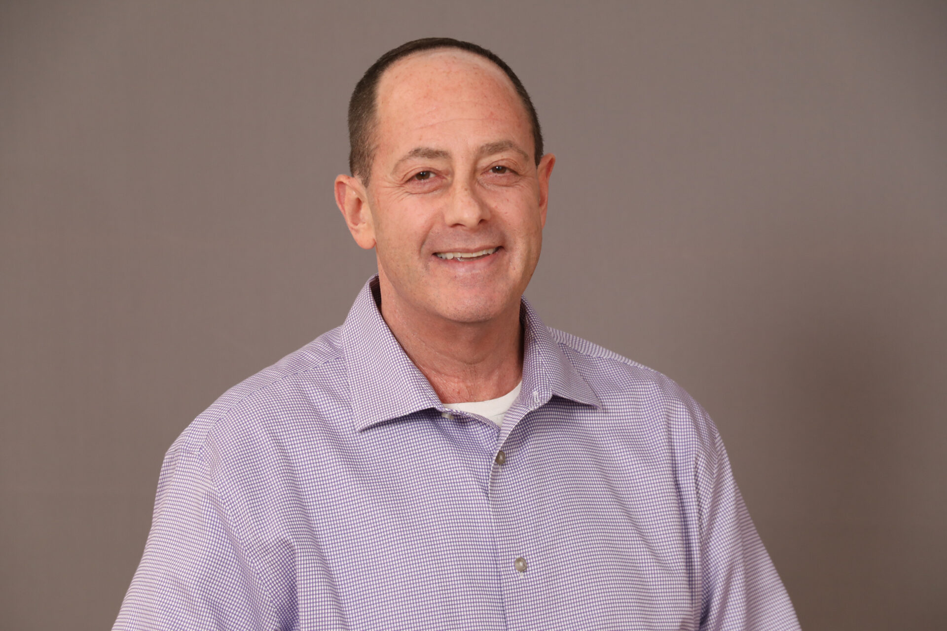 Headshot of a man in a purple shirt