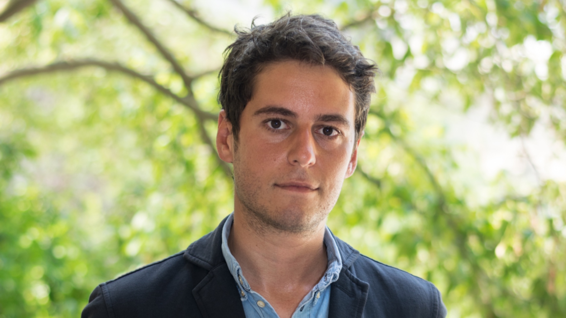 Gabriel Attal headshot with a tree in the background