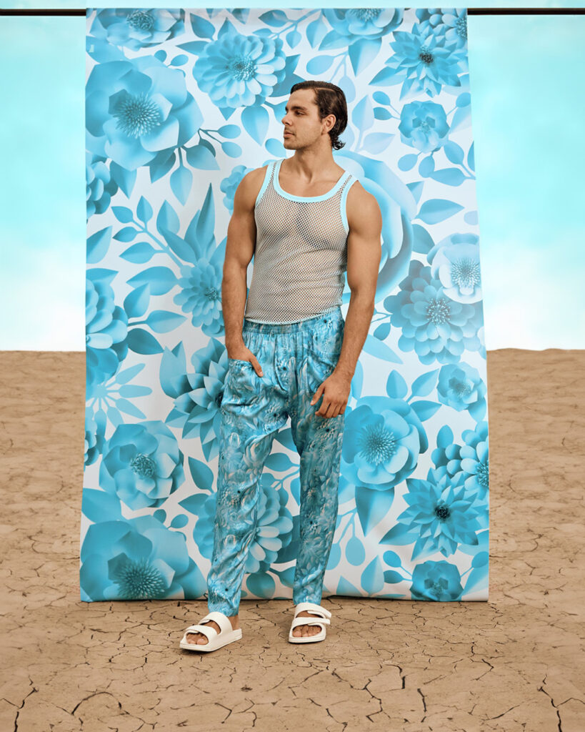 Male model wearing a mesh vest and blue trousers
