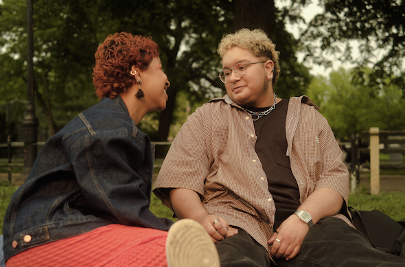 A trans couple sitting in a park