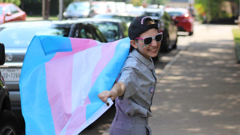 A young trans boy with a trans flag