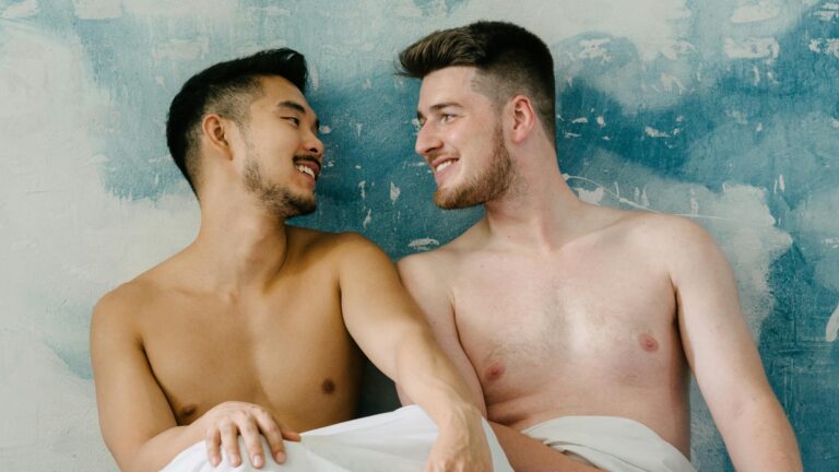 Two topless men in bed