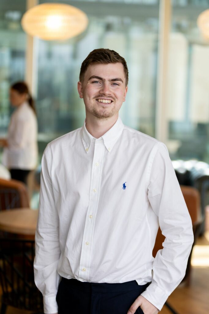 A smiling man in a white shirt 