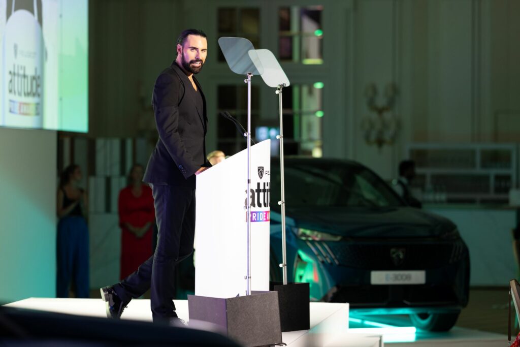 Rylan stands onstage at the PEUGEOT Attitude Pride Awards