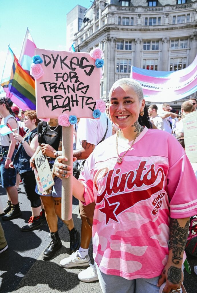 an attendee holding a sign saying 'dykes for trans rights'