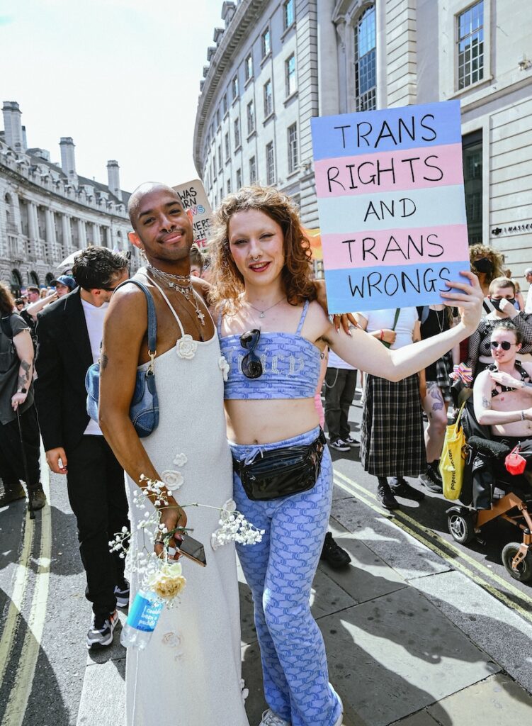 Two marchers, one with a sign saying 'trans rights and trans wrongs'