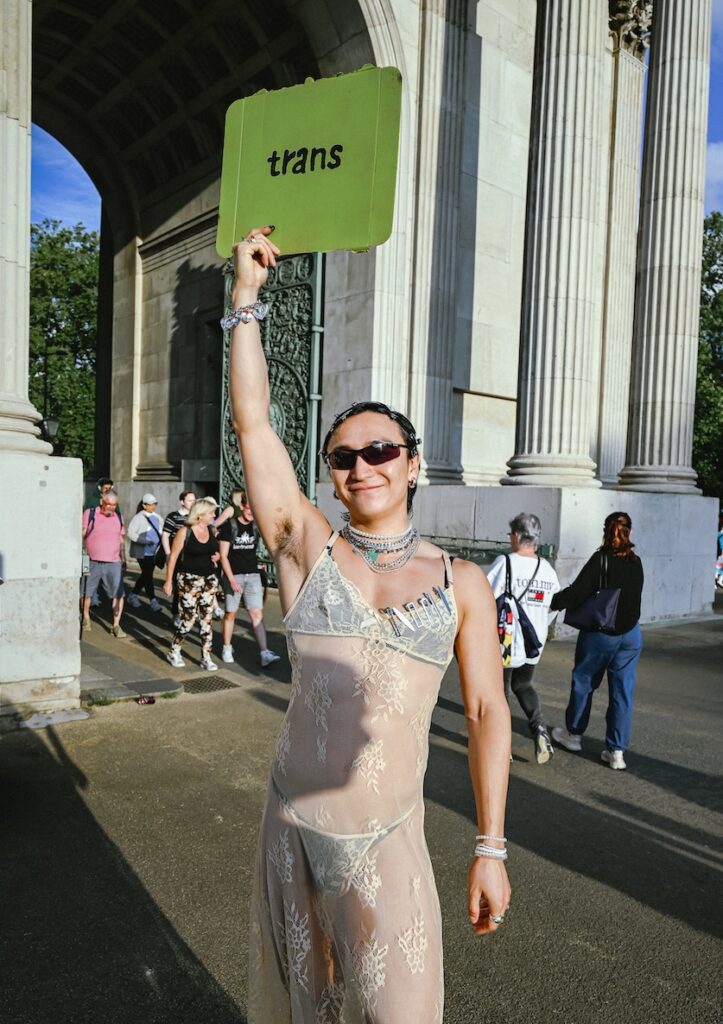 this person's sign simple says 'trans' in the Charli XCX Brat meme font and colour