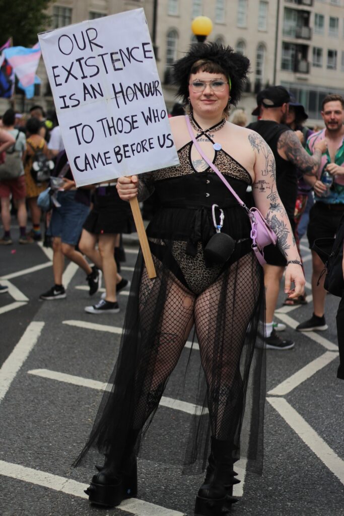 an attendee holding a sign saying 'our existence is an hour our to those who came before us'