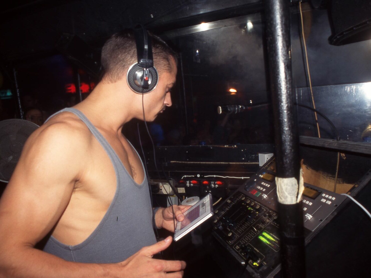 A Dj wearing headphones in a DJ booth