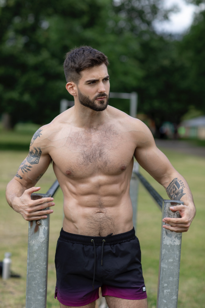 Vince again topless against a tree and grass background