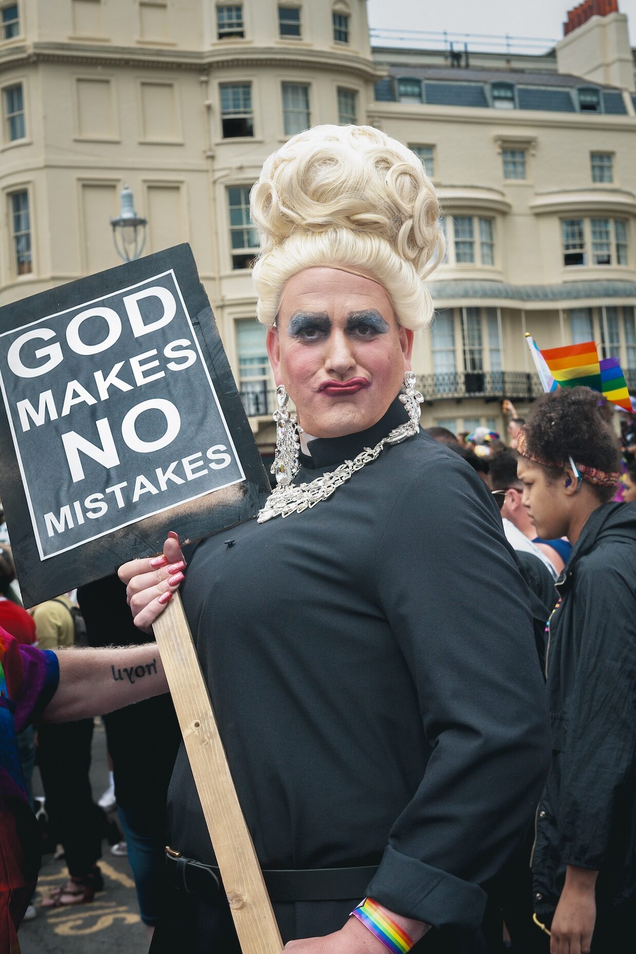 An attendee holding a sign saying 'God Makes No Mistakes'