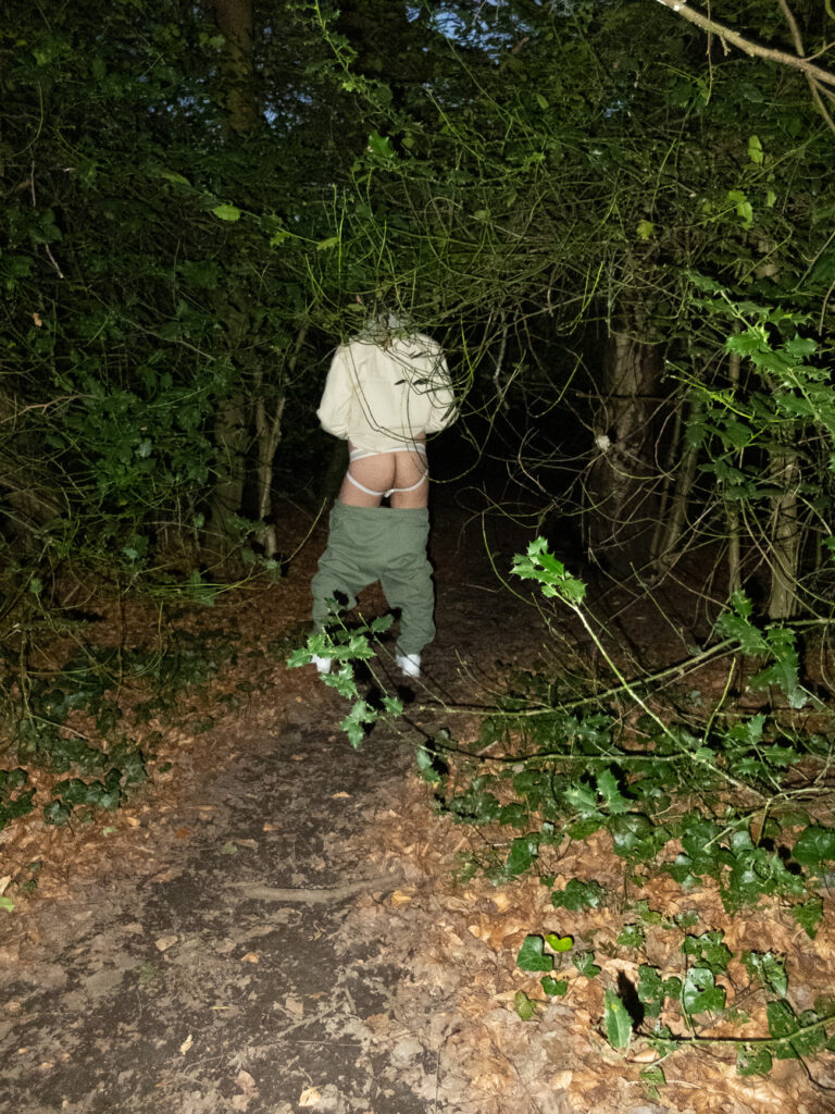 someone in a forest at night with their trousers down