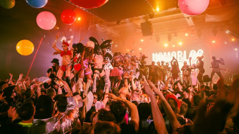 Crowd of people in a nightclub cheering on performers