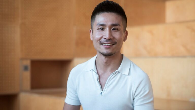 A smiling man wearing a white shirt