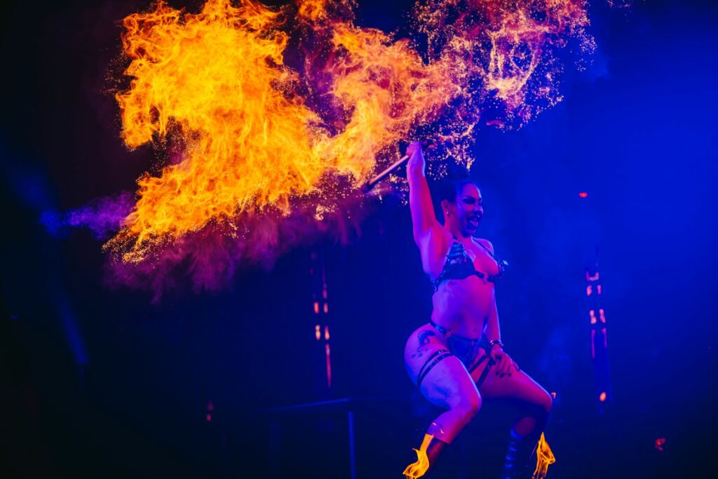 A performer twirls a fire baton