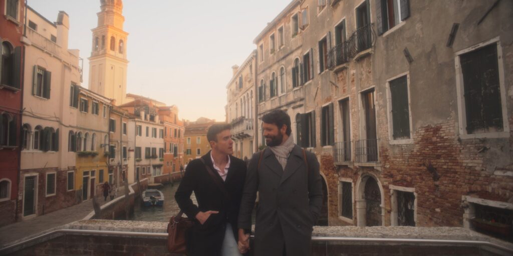 Two man stand on a bridge in Venice