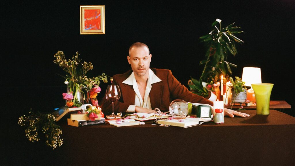 Will Young sitting at a desk surrounded by plants