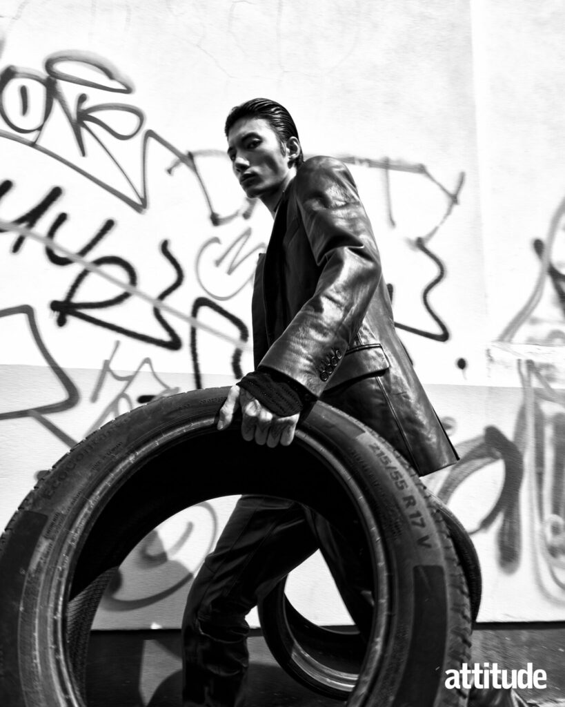 Model lifts tyres in Dsquared2 leather blazer and trousers 