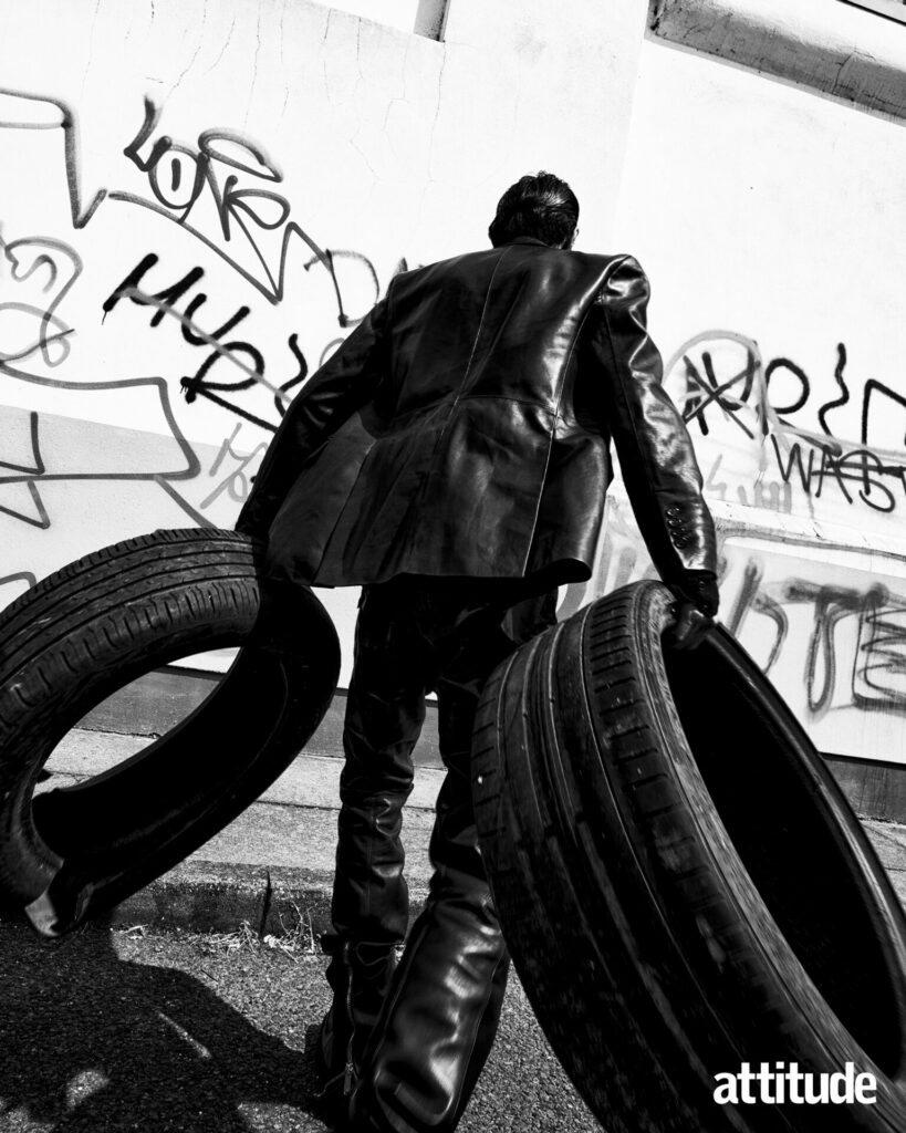 Model lifts tyres in Dsquared2 leather blazer and trousers 