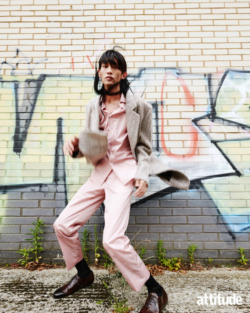 Model poses against in graffiti wall in pink two piece by Prada