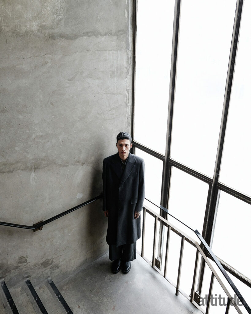 Model poses in stairway in black Fendi overcoat