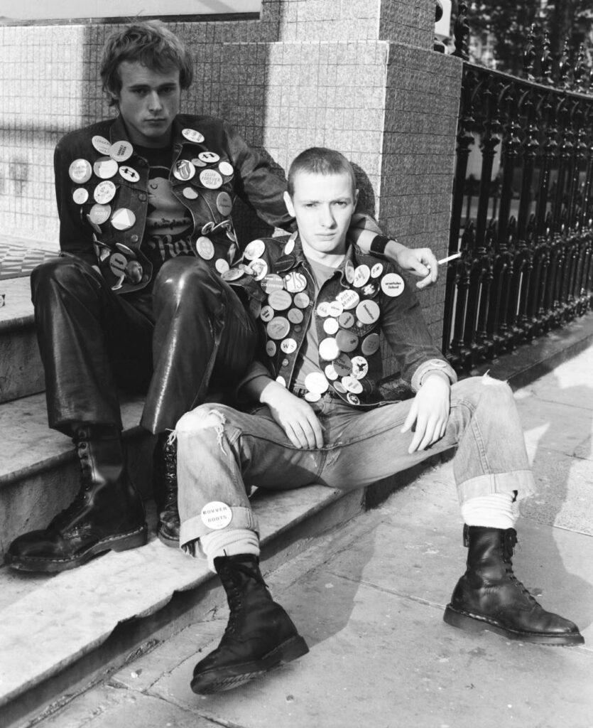 Black and white image of two punks sitting on the street