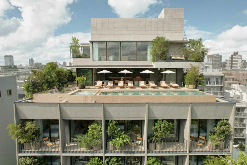 View of a tall hotel overlooking Tokyo with plants on its balconies