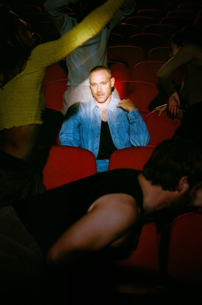 Will Young sitting in a red seat