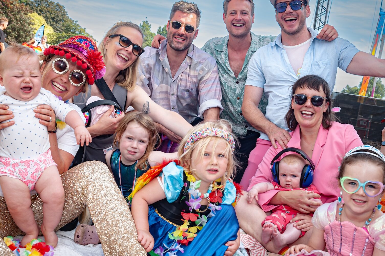 A group of parents with kids at Brighton and Hove Pride 2024 pose for the camera