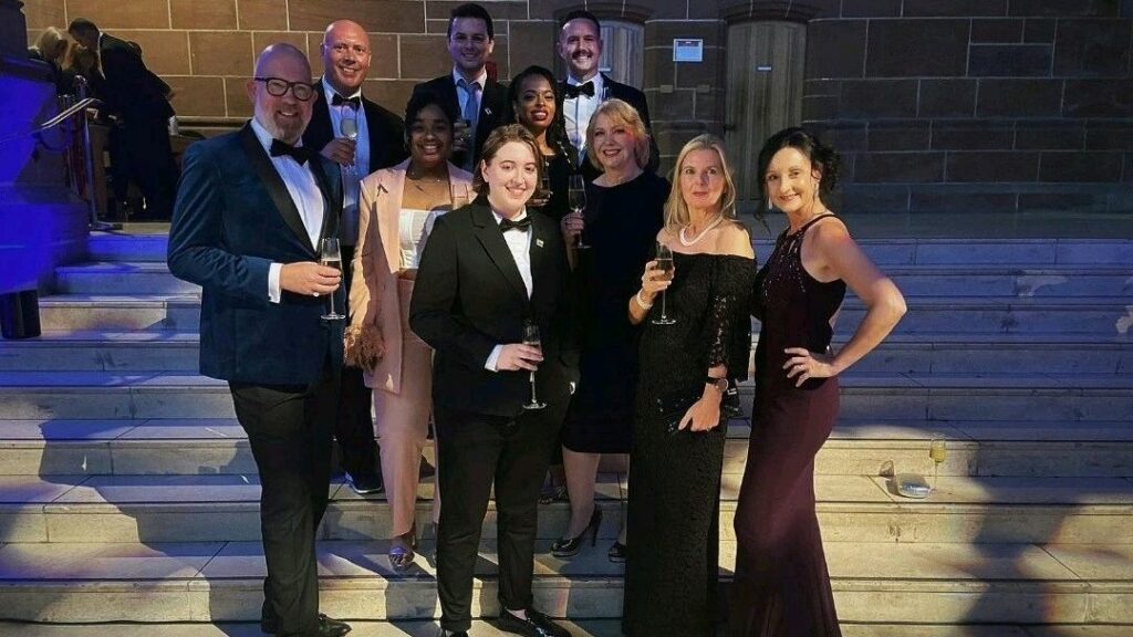 A group of people in black tie and dress standing on steps