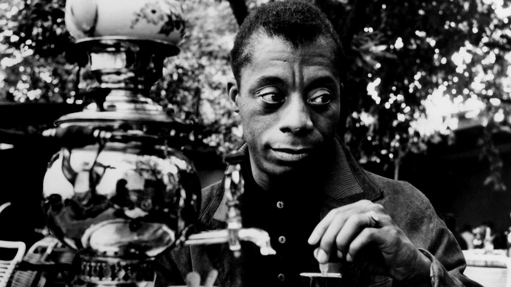 James Baldwin standing by a lantern