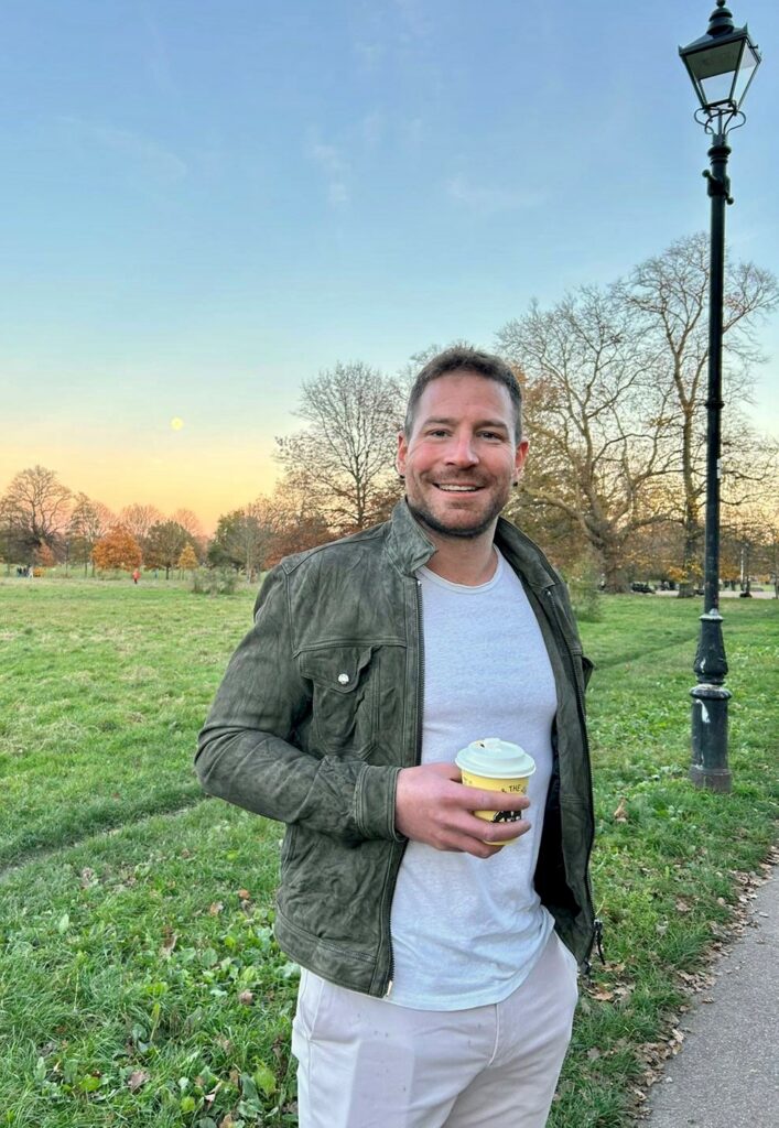 A smiling man in a park