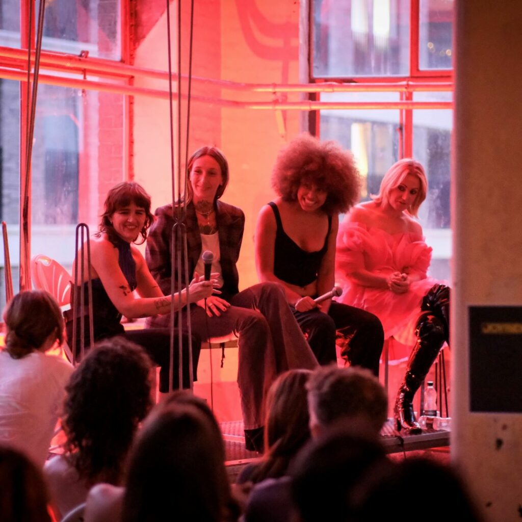 A group of people sitting on stools on a stage