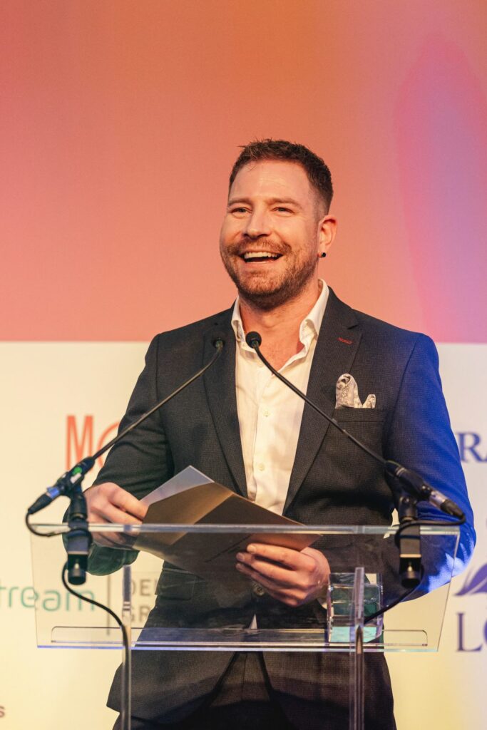 A smiling man accepting an award