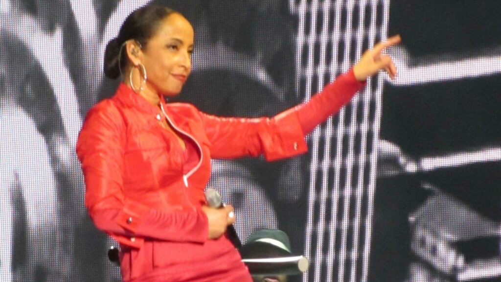 Sade on stage in a red dress