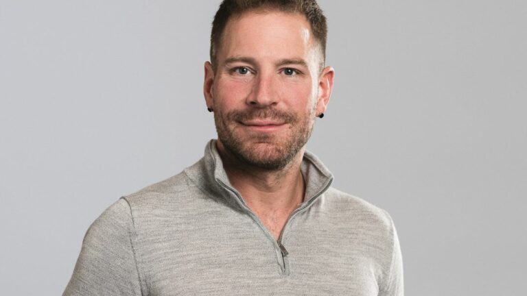 A smiling man in a grey top