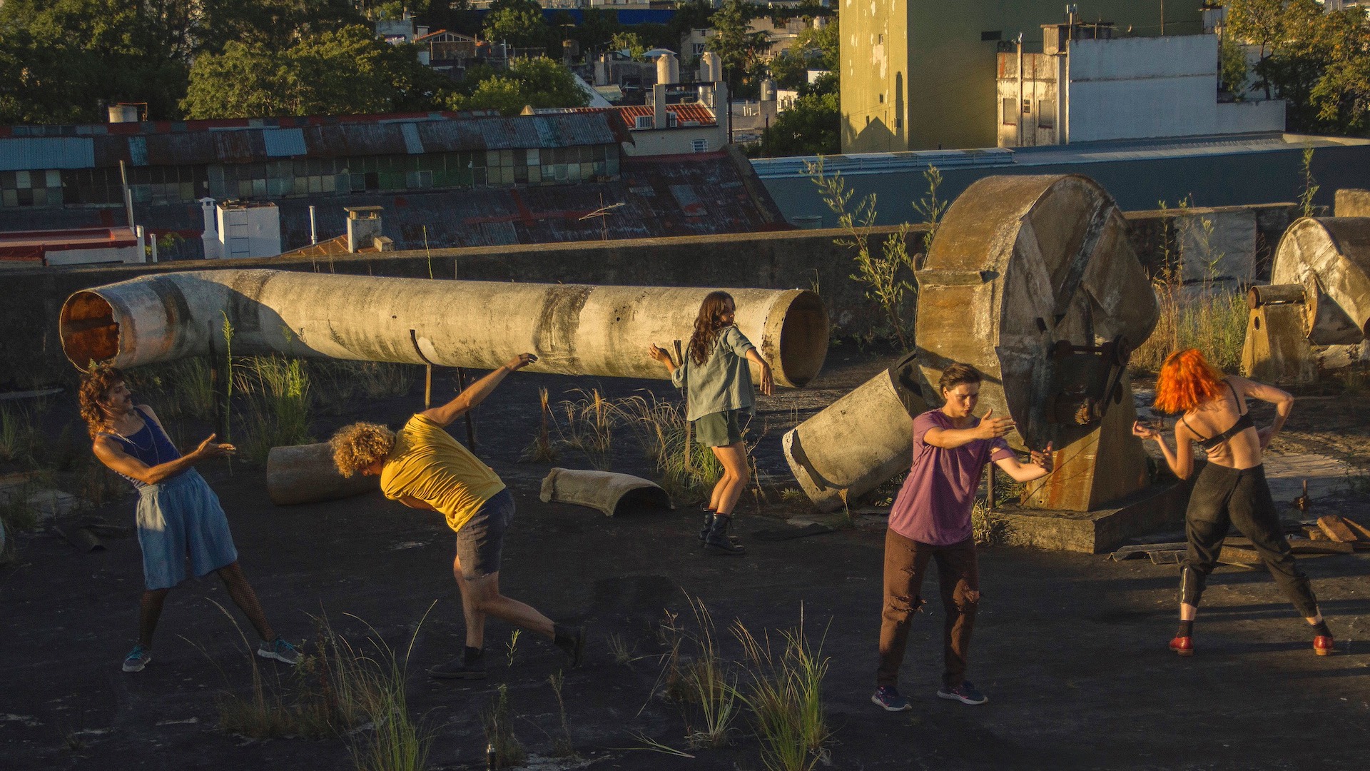 five people dancing on an industrial estate