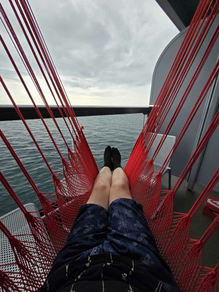 A man relaxing on a hammock at sea