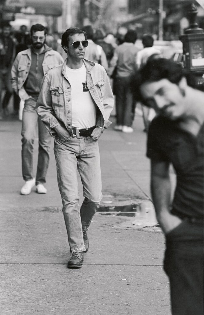 three men walking down. street in black and white