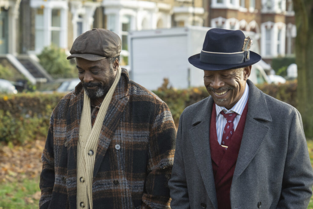 the characters in hats and warm clothes waking down a street