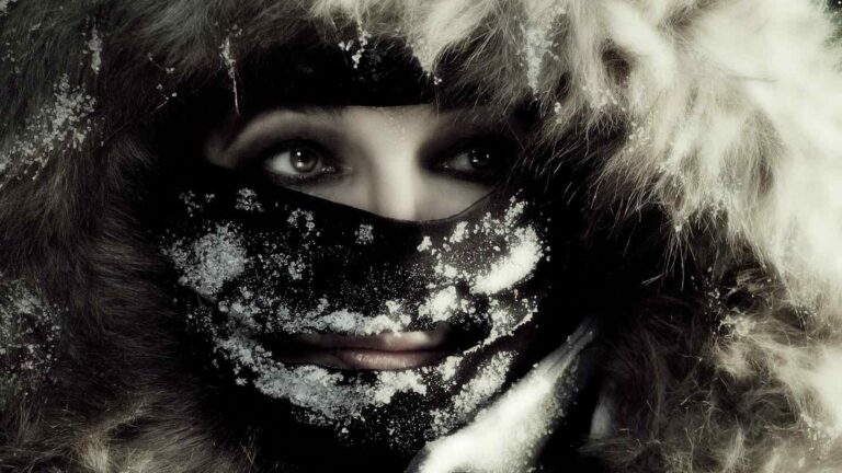 Close crop of Kate Bush wearing a face mask covered in snow