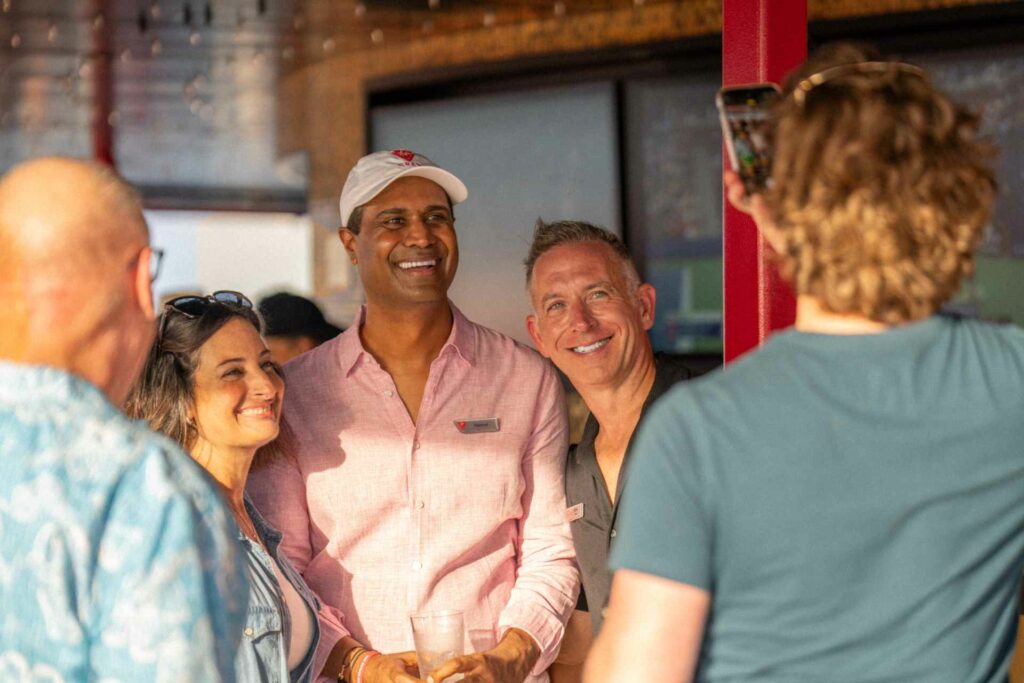 A group of people smile together into the camera