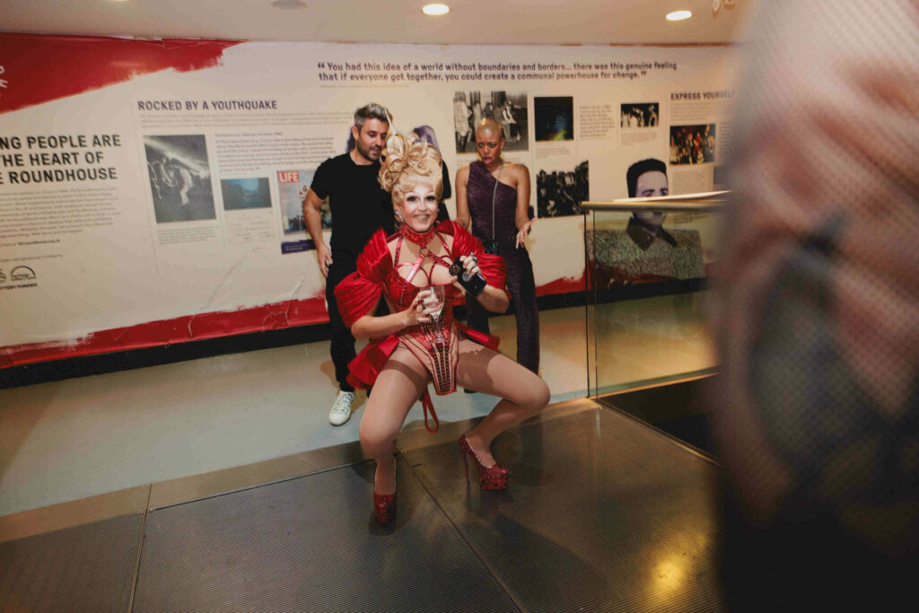 The drag queen Tess Tickle in a red outfit