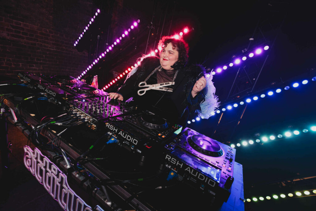 Barbara Butch DJing with a scissors necklace