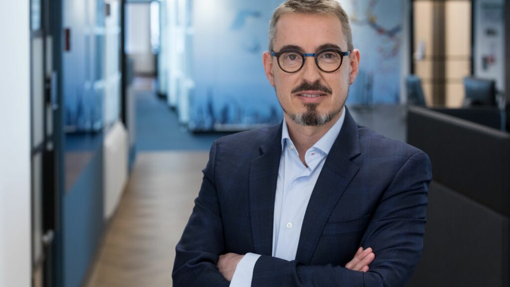 A smiling man in a suit and glasses