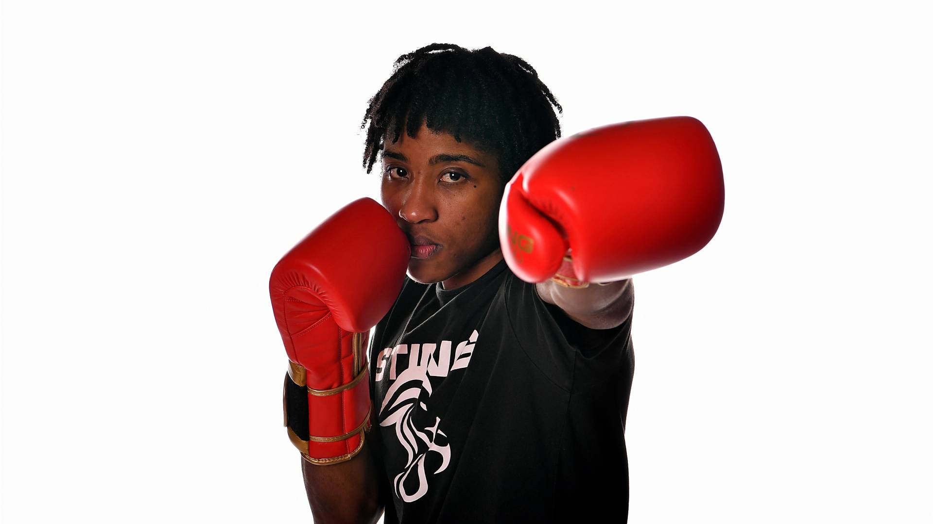 The boxer Cindy Ngamba wearing red boxing gloves punching towards the camera