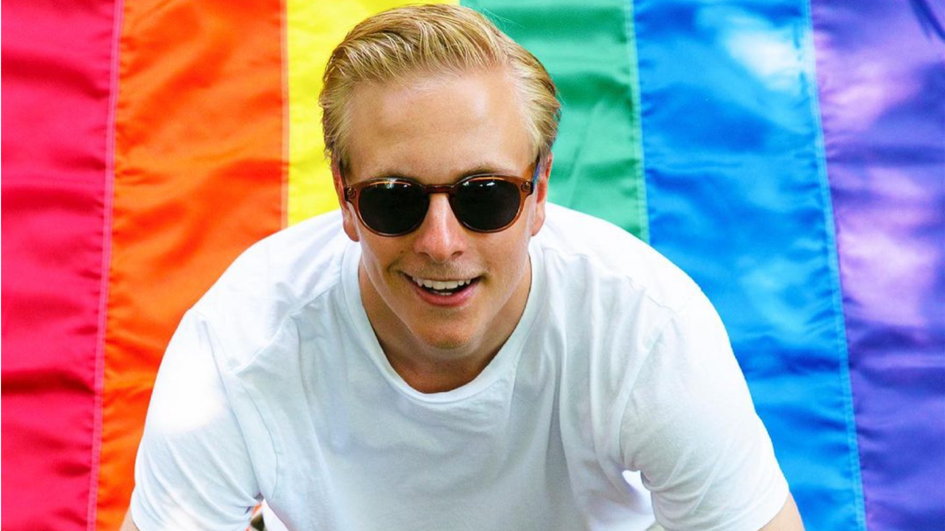 Janne Puhakka, the gay Finnish ice hockey player, sitting on a pride flag