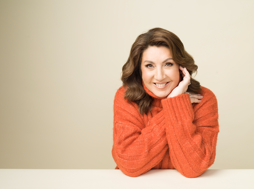 Jane smiling in an orange jumper