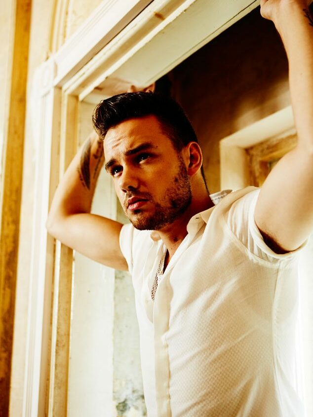 Liam in a white shirt holding a door frame