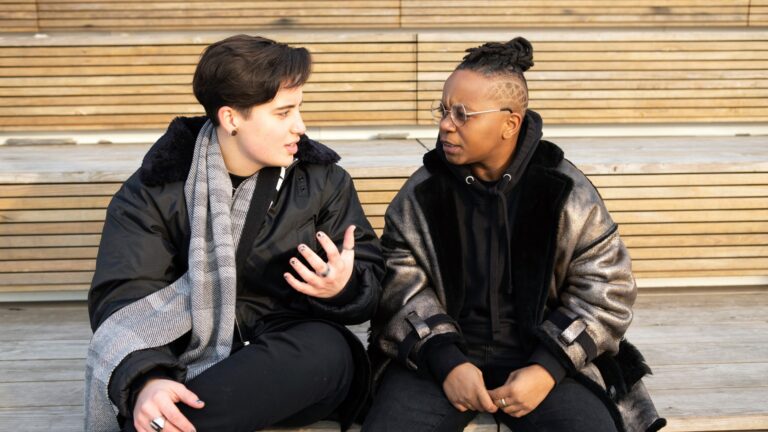 two friends having a conversation, posed by models